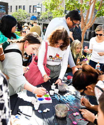 photo of people doing crafts at a table outside