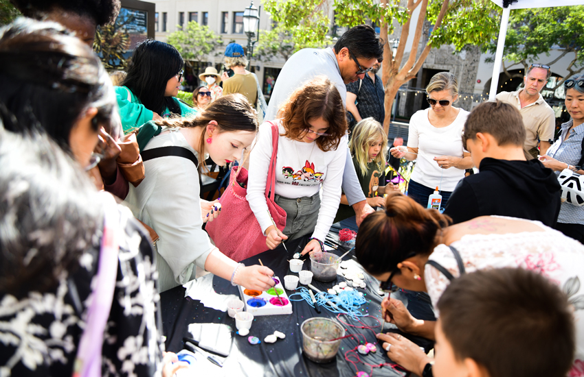 photo of people doing crafts at a table outside