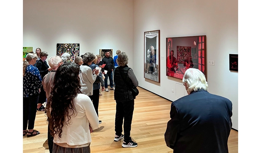 Photo of group of adults standing in a gallery looking at art