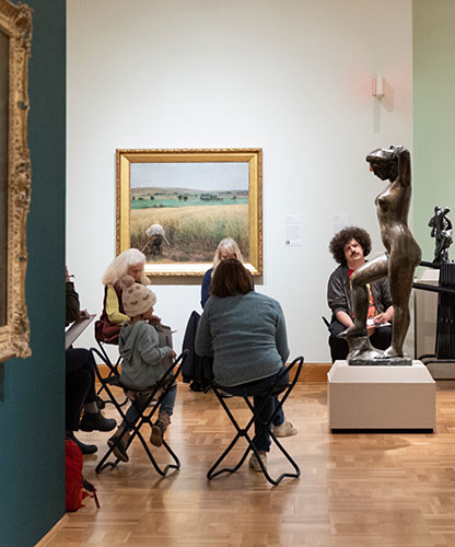 photo of people sitting around a sculpture drawing