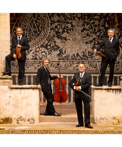 photo of four musicians holding their string instruments standing in a U formation on some steps outside an old building with columns