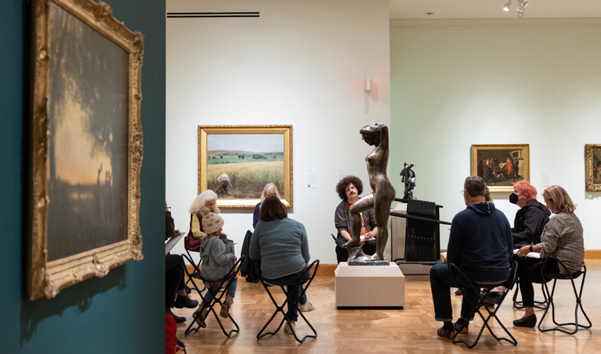 photo of people in a gallery sketching a sculpture