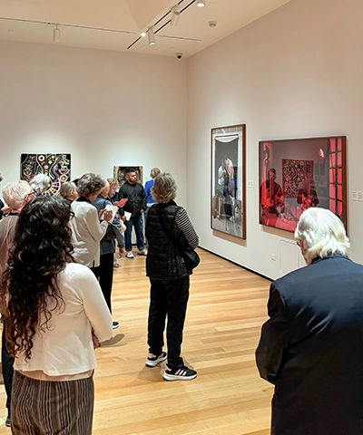 Photo of group of adults standing in a gallery looking at art