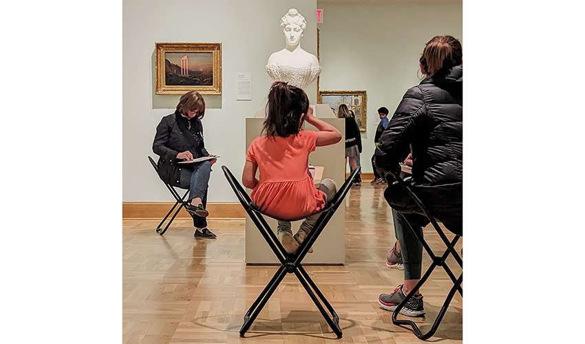 people sitting around a plaster bust sketching in the galleries