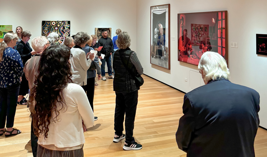 Photo of group of adults standing in a gallery looking at art