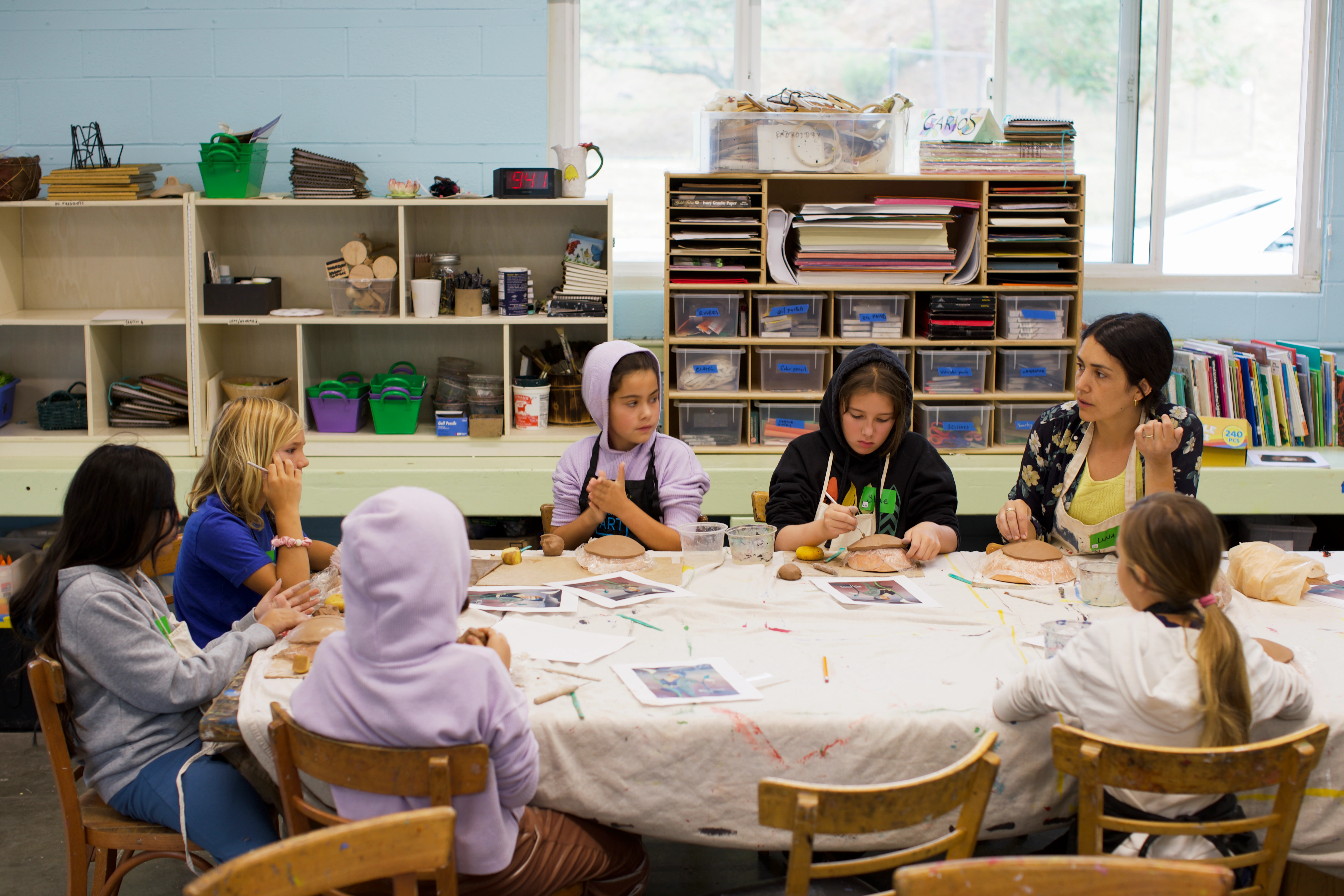 photo of young children crafting at a table being led by an instructor