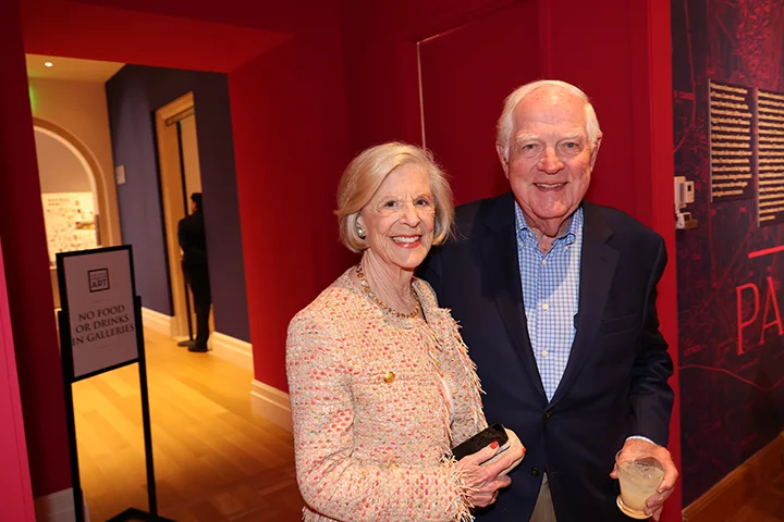 a man and woman in cocktail attire smiling at the camera