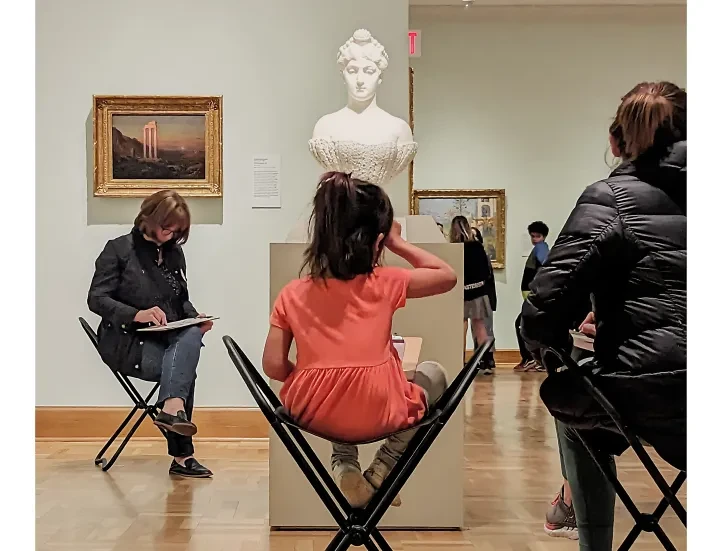 people sitting around a plaster bust sketching in the galleries