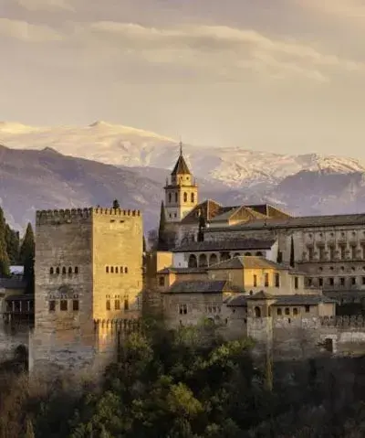 Photo of exterior of building in Alhambra with mountain range in background