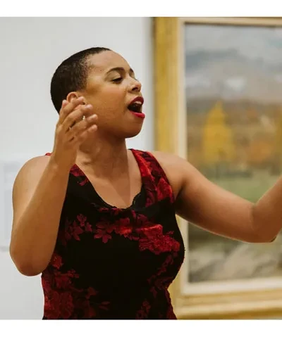 photo of opera singer in red dress singing in museum gallery