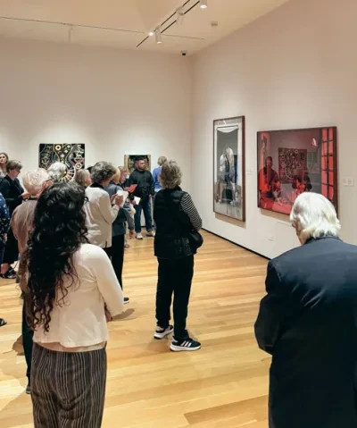 Photo of group of adults standing in a gallery looking at art