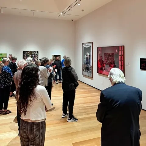 Photo of group of adults standing in a gallery looking at art