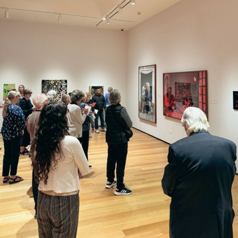 Photo of group of adults standing in a gallery looking at art