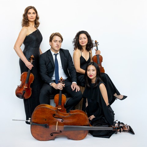 photo of quartet musicians with their instruments seated and standing against a bluish white gradient backdrop