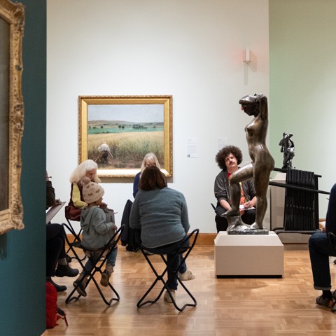 photo of people in a gallery sketching a sculpture