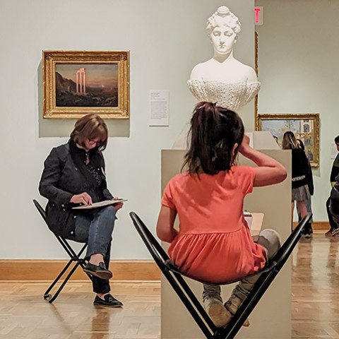 people sitting around a plaster bust sketching in the galleries